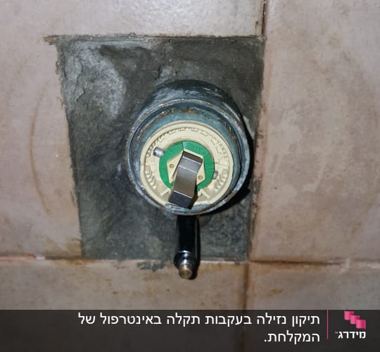 שסתום מים בקיר עם ידית מתכת